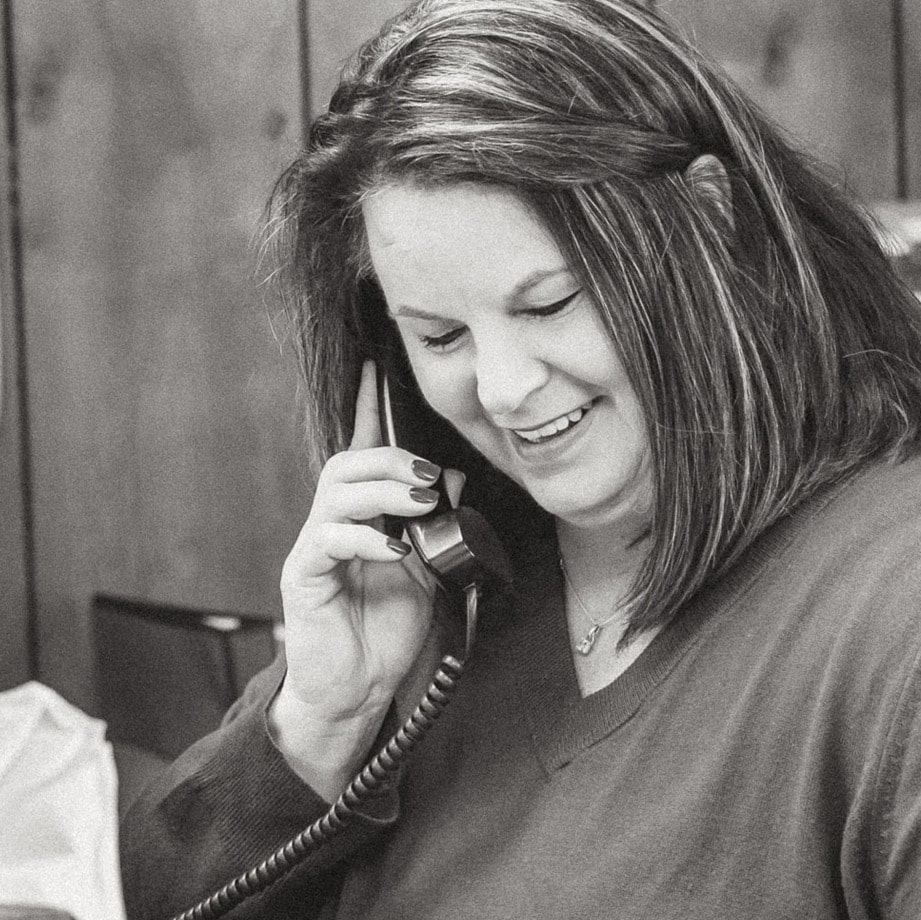 Kimberly smiling while talking to a customer on the phone.