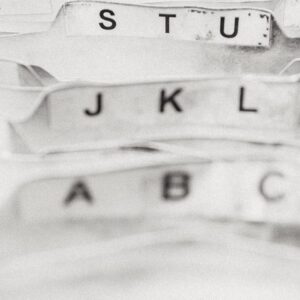Letters visible on the tabs of paper file folders.